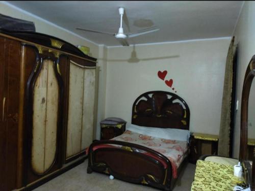 um quarto com uma cama com corações na parede em my hotel em Minia