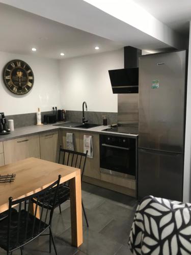 La cuisine est équipée d'une table, d'une cuisinière et d'un réfrigérateur. dans l'établissement Petite maison, à Carcassonne