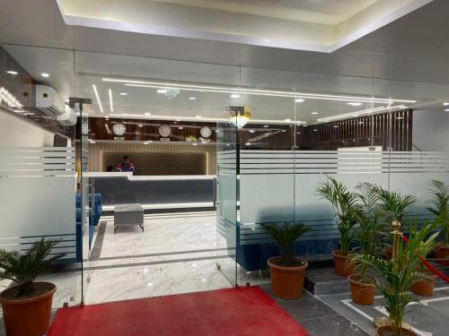 a lobby with potted plants and a reception desk at HOTEL MAA LAXMI PALACE in Deoghar