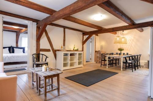 a dining room and living room with wooden beams at Købmandsgaarden Kerteminde in Kerteminde