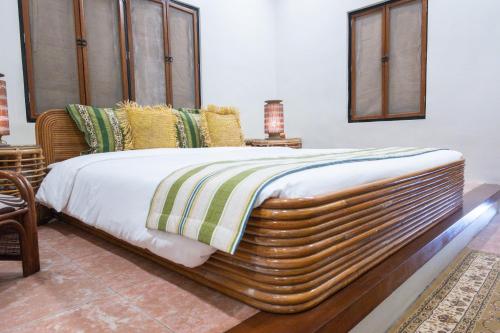 a large bed with a wooden headboard in a room at Nawa Wellness in Calatagan