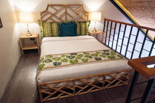 a bedroom with a bed and two lamps on tables at Nawa Wellness in Calatagan
