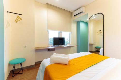 um quarto com uma cama grande e uma televisão em Sans Hotel Kelapa Gading Jakarta em Jakarta