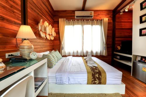 a bedroom with a large bed with a window at The Cottage Aonang in Ao Nang Beach