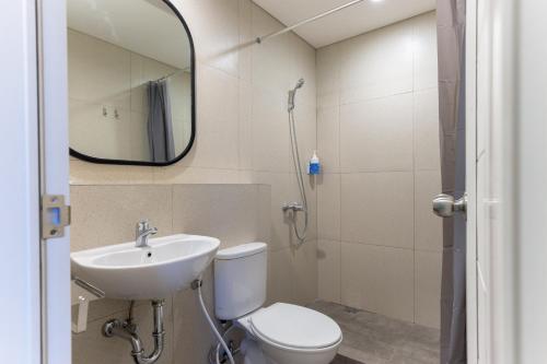 uma casa de banho com um WC, um lavatório e um espelho. em Sans Hotel Kelapa Gading Jakarta em Jakarta