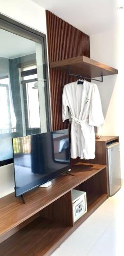 a mirror and a tv on a shelf with a robe at The Dragon Villa Hoi An in Hoi An