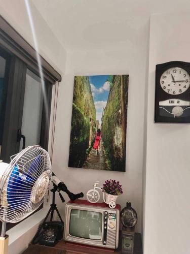 a room with a tv and a picture on the wall at The Dragon Villa Hoi An in Hoi An