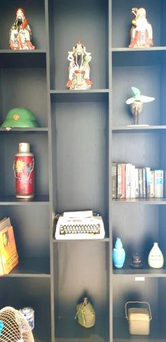 a book shelf with a keyboard and other items on it at The Dragon Villa Hoi An in Hoi An