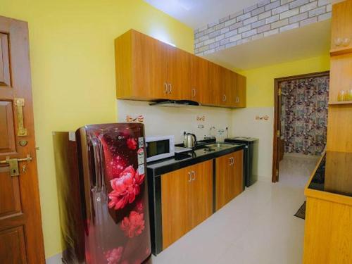 a kitchen with a refrigerator with flowers on it at Beachside Bliss Apartment in Colva Salcette- Goa in Colva
