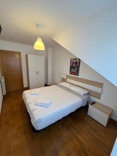 1 dormitorio con 1 cama blanca grande en el ático en MR, en Villaviciosa