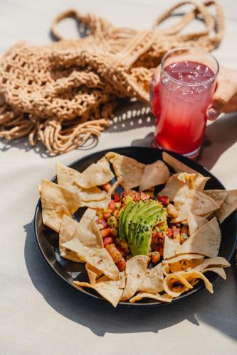een bord eten met tortillachips en een drankje bij Bora Boutique - Adults Only in Puerto Escondido