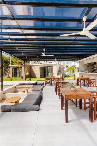 a patio with wooden tables and benches and blue ceilings at Bora Boutique - Adults Only in Puerto Escondido