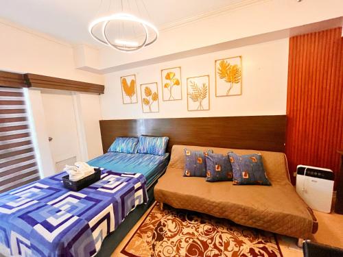 une chambre avec deux lits et un canapé dans l'établissement BRENT STUDIO ROOM IN TAGAYTAY WITH TAAL LAKE VIEW, à Tagaytay