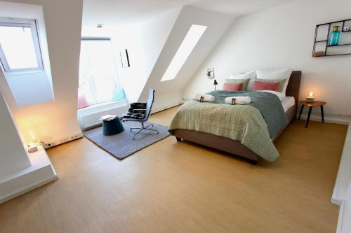 um quarto com uma cama e uma cadeira em The Suites City Lofts at the Park em Hamburgo