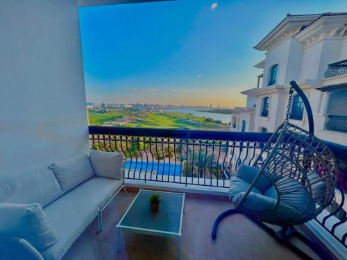 uma sala de estar com um sofá e um baloiço numa varanda em Tranquil Haven Perfect Retreat for Your Holiday 510 em Abu Dhabi