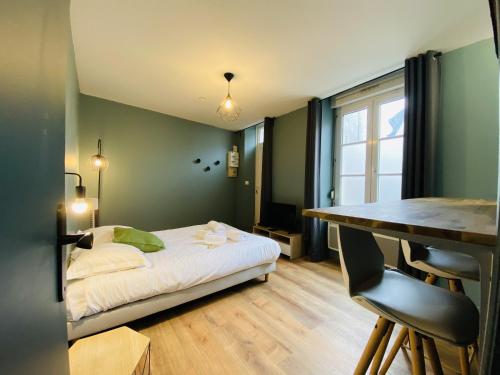 une petite chambre avec un lit et une table dans l'établissement Casa Balzac - Studio, à Angers