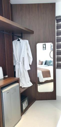 a room with a mirror and a white robe at The Dragon Villa Hoi An in Hoi An