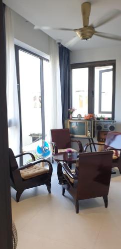 a living room with chairs and tables and windows at The Dragon Villa Hoi An in Hoi An