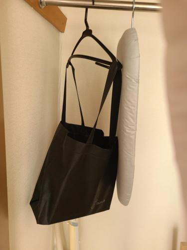 a black bag and a pillow hanging on a wall at ホテルサンクリスタ4階 in Tokyo