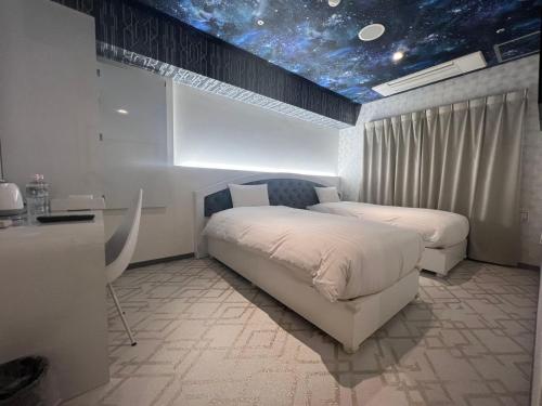 2 camas en una habitación con techo estrellado en Hotaku HOTEL Akihabara, en Tokio
