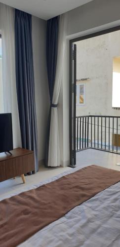 a bedroom with a bed and a sliding glass door at The Dragon Villa Hoi An in Hoi An