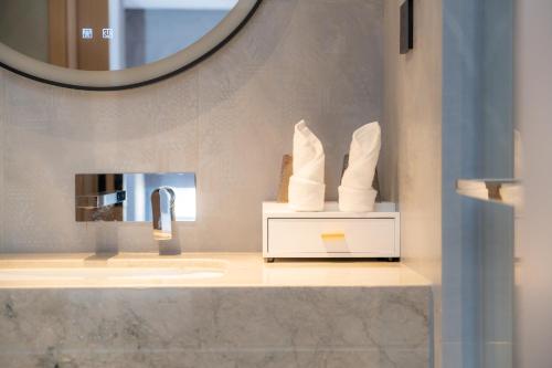 a bathroom with a sink and a mirror at Rongye Hotel - Gaozhuang Xishuangjing Starlight Night Market Branch in Jinghong