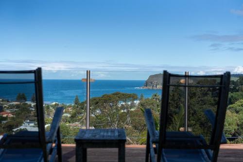 a view of the ocean from a balcony with chairs at Copa Sunset Surprise - Modern and Stylish Simplicity in Copacabana