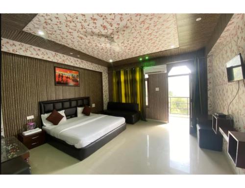 um quarto com uma cama e um sofá em Hotel Tulsi, Rudraprayag em Rudraprayāg