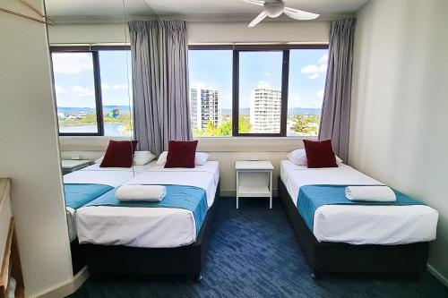 Habitación de hotel con 2 camas y ventana grande. en Tiki Hotel Apartments Surfers Paradise en Gold Coast