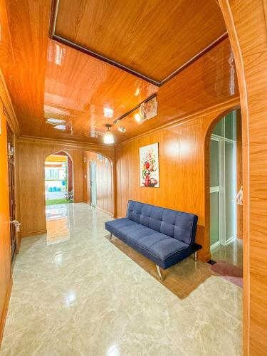 a living room with a blue couch in the middle at Đại Đạt Homestay - đảo Phú Quý in Cu Lao Thu