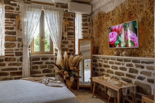 ein Schlafzimmer mit einem Bett und einem TV an der Wand in der Unterkunft Lithos Messolongi Paradise - A Luxurious Retreat in Mesolongi