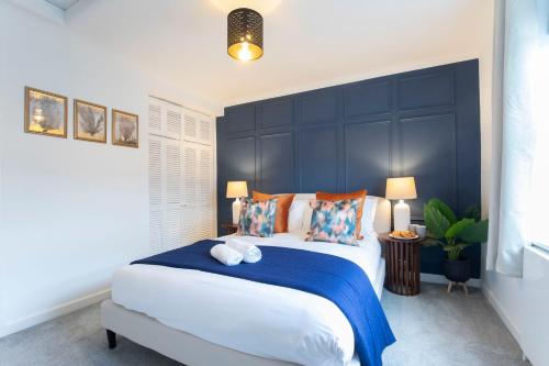 a bedroom with a large bed with a blue headboard at Beautiful Victoria Retreat in Cheltenham