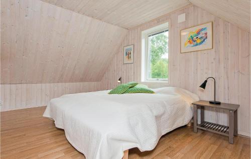 een slaapkamer met een wit bed en een raam bij Stunning Home In Holmsj With Kitchen in Holmsjö