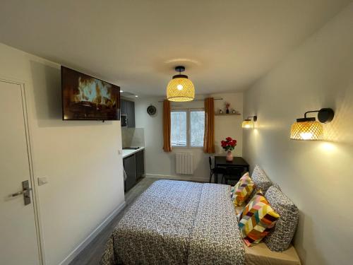 Cette petite chambre comprend un lit et une cuisine. dans l'établissement studio les 8 jasmins mignon et neuf, à Tremblay-en-France