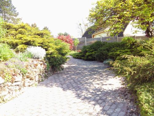 a cobblestone walk way in a garden with bushes at Chambre Marine in Château-Thierry