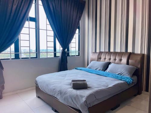 a bed in a bedroom with blue drapes at HCK24 2br Aeon Bukit Indah Legoland Johor Bahru in Johor Bahru