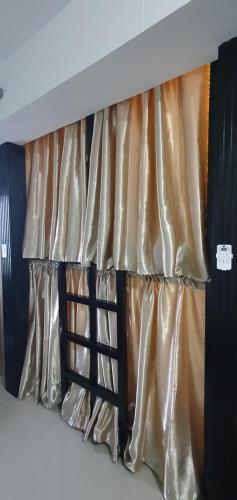 uma cama com cortinas douradas e pretas num quarto em C Place - Capsule B em Manila