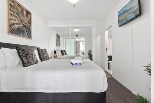 a bedroom with a large white bed in a room at Lux Retreat - Sauna pool & prime location in Cairns