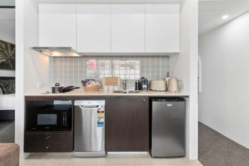 a kitchen with stainless steel appliances in a room at Lux Retreat at Harbour Light Cairns I Sauna I Pool & prime Location in Cairns
