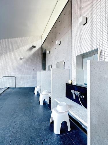 a waiting room with white benches in a building at Karuizawa Tennku Hotel & Resort in Karuizawa