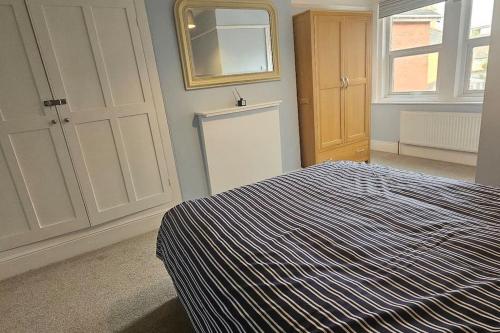 a bedroom with a bed and a mirror on the wall at Avocet View *sleeps 10* in Exmouth