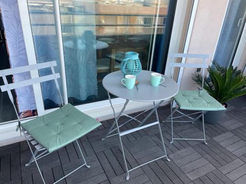 a table and two chairs and a vase on a balcony at Magnifique 2 pièces Juan Les Pins in Antibes