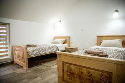 - 2 lits dans une chambre dotée de parquet dans l'établissement Jelena Apartmani, à Sombor