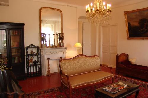 a living room with a chair and a mirror at Hotel-Restaurant Le Vieux Moulin in Centuri