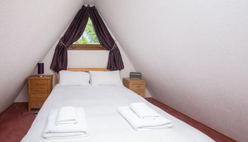 1 dormitorio con 1 cama con sábanas blancas y ventana en Chalet Sixtytwo, en Deal
