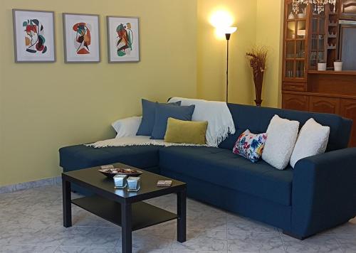 a blue couch in a living room with a table at Kelly's penthouse in Nafpaktos