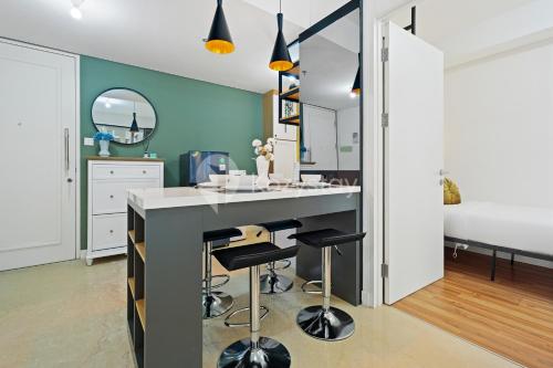 a kitchen with a island with bar stools at Kiara by Kozystay - Paskal in Bandung