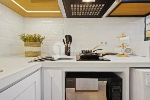 a kitchen with a stove top oven next to a counter at Kiara by Kozystay - Paskal in Bandung