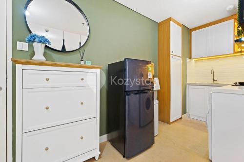a kitchen with a refrigerator and a mirror at Kiara by Kozystay - Paskal in Bandung