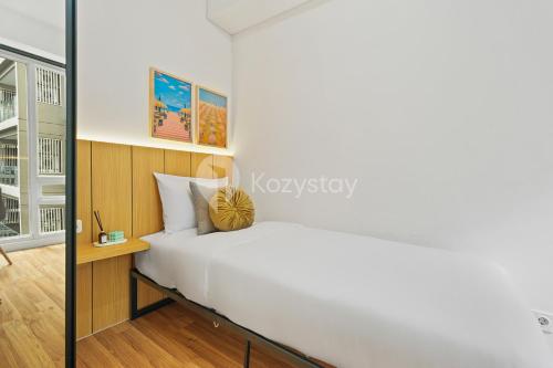 a bedroom with a white bed and a mirror at Kiara by Kozystay - Paskal in Bandung
